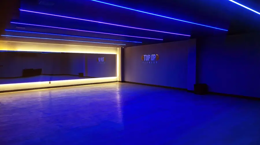 Sala de aulas coletivas iluminada em azul na unidade CT Aldeota